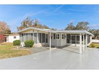 Inviting single-story home featuring a spacious carport and well-manicured front lawn at 11 Orangewood Dr, Fruitland Park, FL 34731