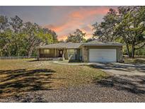Charming single story home featuring stone accents, a two-car garage, and a lovely front porch at 3380 Cr 528, Sumterville, FL 33585