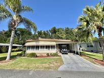 Charming single-story home with lush landscaping and a covered carport for convenient parking at 114 Chestnut St, Leesburg, FL 34748