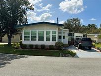 Single-wide manufactured home with carport and landscaped yard at 123 Pyracantha Ln, Leesburg, FL 34748