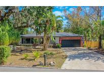 Brick ranch home with a landscaped yard and a black garage door at 1625 Virginia Dr, Clermont, FL 34711