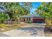 Charming single-story home with a brick facade, lush landscaping, and a two-car garage at 1625 Virginia Dr, Clermont, FL 34711