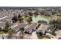 A sunny aerial view of homes surrounding a lake in a residential neighborhood at 17760 Se 91St Gaylark Ave, The Villages, FL 32162