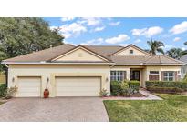 Beautiful two-story home with three-car garage and manicured lawn at 2420 Prairie Dunes, Clermont, FL 34711