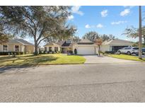 Single-story home with a two-car garage and well-maintained lawn at 26709 Augusta Springs Cir, Leesburg, FL 34748