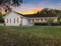 Beautiful one-story home with white siding, brown roof, and landscaped lawn at 51 Cr 532B, Bushnell, FL 33513