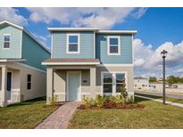 Two-story light blue house with gray accents and a landscaped front yard at 17006 Clear Mind Aly, Winter Garden, FL 34787