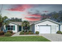 Charming single-story home with a well-manicured lawn, lush landscaping and a two-car garage at 3315 Woodridge Dr, The Villages, FL 32162