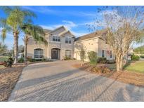 Two-story house with a brick facade, a three-car garage, and a landscaped yard at 3463 Creek Run Ln, Eustis, FL 32736