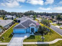 Aerial view of a single-Gathering home with a two-car garage and landscaped yard at 4002 Richmond Xing, Leesburg, FL 34748