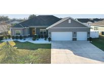 Gray house with two-car garage and landscaped lawn at 10300 Se 69Th Ter, Belleview, FL 34420