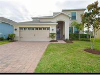 Two-story house with a three-car garage and landscaped lawn at 2287 Victoria Dr, Davenport, FL 33837