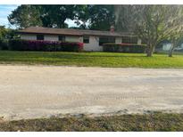 Charming single-story home featuring a well-maintained lawn and colorful flowering bushes at 24450 Ne 127Th St, Salt Springs, FL 32134