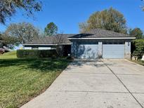 Charming single-story home with a well-manicured lawn and two-car garage at 2613 Crest Dr, Haines City, FL 33844