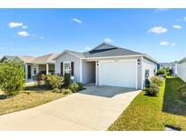 Charming single-story home with a well-maintained lawn and a concrete driveway leading to an attached garage at 3822 Miragalia Ln, The Villages, FL 32163