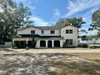 Two-story house with white exterior, dark roof, and landscaping at 4520 N Hiawassee Rd, Orlando, FL 32818