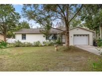 House exterior featuring a ranch-style home with a single garage and well-maintained lawn at 5301 Se 115Th Pl, Belleview, FL 34420