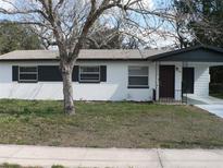 Charming single-story home with neutral paint, dark shutters, covered entry and landscaped front yard at 703 Sullivan Ave, Ocoee, FL 34761