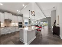 Spacious kitchen with island, stainless steel appliances, and white cabinetry at 8493 Hartford Way, Mount Dora, FL 32757