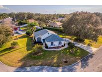 Beautiful, landscaped single Gathering home featuring lush lawn, mature trees and driveway in a quiet neighborhood at 85 Golfview Cir, Umatilla, FL 32784