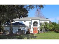 Two-story house with a red door, white walls, and lush landscaping at 1001 Willa Lake Cir, Oviedo, FL 32765