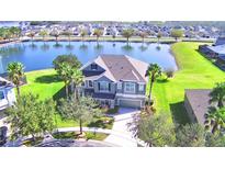 Two-story house with lake view, lush landscaping, and spacious yard at 113 Pecorri Ct, Auburndale, FL 33823