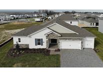 Two-story home with stone accents and a three-car garage at 14261 Crest Palm Ave, Windermere, FL 34786