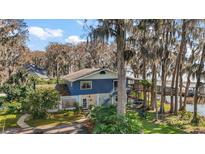 Charming two-story lake house with blue siding and a unique elevated walkway at 1702 N County Road 452, Eustis, FL 32726