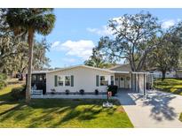 Single-story home with carport and landscaped lawn at 25547 Belle Helene, Leesburg, FL 34748