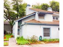 Cute two-story house with light blue accents and landscaping at 4437 Cluster Dr, Orlando, FL 32808