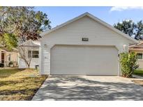 White house exterior with a two-car garage and well-maintained landscaping at 5513 Shriver St, Leesburg, FL 34748