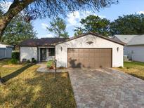 Single story home with brown garage door and paved driveway at 819 Bolivar St, The Villages, FL 32159