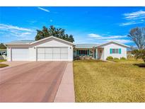 Charming single Gathering home with a large driveway and well-manicured lawn at 10347 Se 179Th St, Summerfield, FL 34491