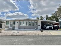 Charming single-story home features a carport and meticulously maintained landscaping with decorative stone at 113 Willow Ln, Leesburg, FL 34748