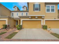 Charming townhome exterior with a brick pathway and well-maintained landscaping and a one car garage at 17523 Promenade Dr, Clermont, FL 34711