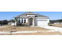 Charming single-Gathering home with stone accents, arched entryway, and a two-car garage at 2803 Supermarine Rd, Tavares, FL 32778