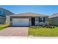 Charming one-story home with a brick driveway, two-car garage, and manicured lawn at 2950 Supermarine Rd, Tavares, FL 32778