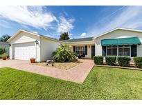 Charming single story home with beautiful landscaping, brick walkway and two car garage at 3218 Woodridge Dr, The Villages, FL 32162