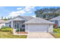 Charming single-story home with a screened porch, two-car garage, and well-manicured landscaping at 5095 China Sea Dr, Tavares, FL 32778