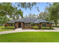Brick home with landscaped yard and driveway at 5910 Lake Emma Ct, Groveland, FL 34736