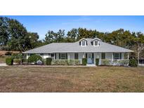 Charming single-story home with a well-manicured lawn and inviting front porch at 10413 Lake Hill Dr, Clermont, FL 34711