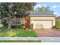 Charming home featuring a brick driveway, attached garage, and well-manicured lawn at 1067 Mesa Verde Court, Clermont, FL 34711