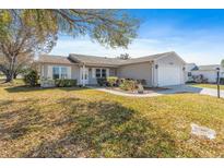 Charming single-story home with a well-manicured front yard and attached garage at 1402 Sanchez Ct, The Villages, FL 32159