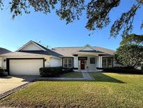 Charming single-story home with a well-maintained lawn, attached garage, and a welcoming red front door at 2041 Park Forest Blvd, Mount Dora, FL 32757