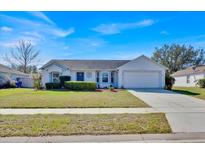 Charming single-story home featuring a well-manicured lawn, attached two car garage and a classic design at 406 Bramble Way, Minneola, FL 34715