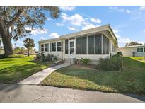 Charming home features a screened lanai, manicured lawn, and inviting front entrance at 8 Gallinule Ct, Fruitland Park, FL 34731