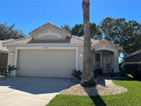 Charming single-story home featuring a two-car garage, tile roof, and well-manicured landscaping at 8004 Saint Andrews Way, Mount Dora, FL 32757