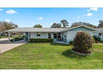 Charming single-story home with a well-manicured lawn and covered carport in a quiet neighborhood at 11820 Watts Ct, Tavares, FL 32778