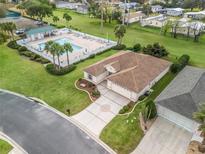 Lovely single-story home with an attached three-car garage and community pool at 12335 Se 176Th Loop, Summerfield, FL 34491