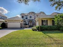 Two-story home boasting a manicured lawn, multi-car garage, stone accents, and a welcoming front facade at 16126 Bristol Lake Cir, Orlando, FL 32828